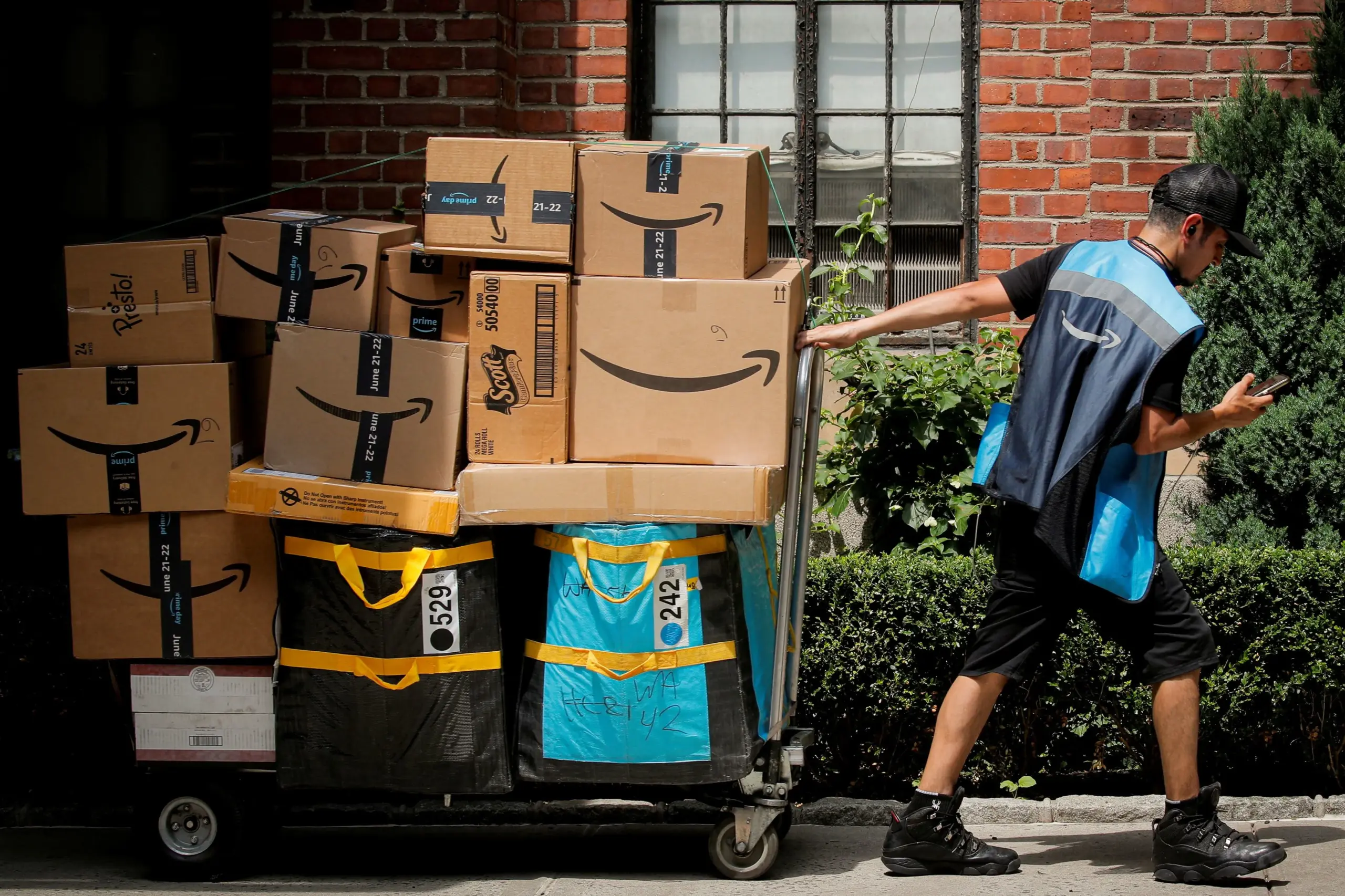 Amazon delivery worker handling packages and inventory boxes.