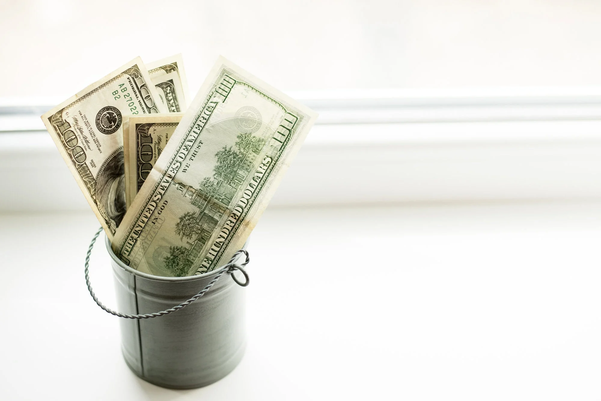 Money bills in a bucket representing savings.