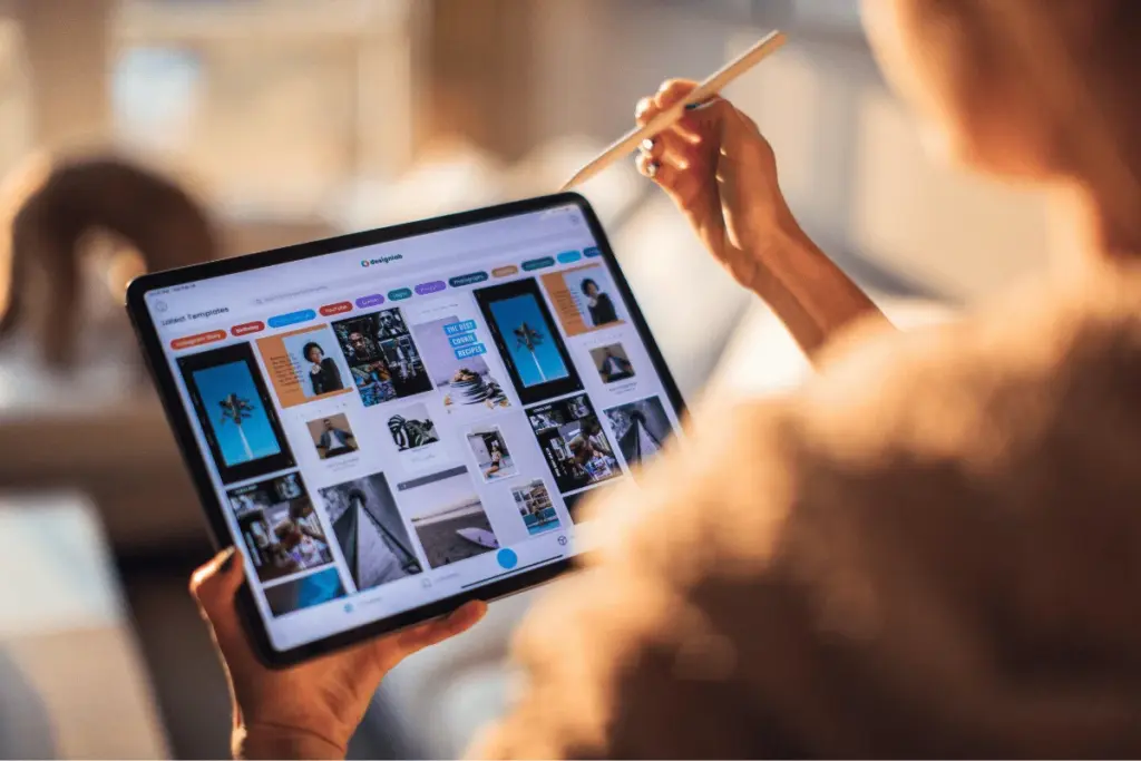 Person using a tablet to view a digital marketing design platform.