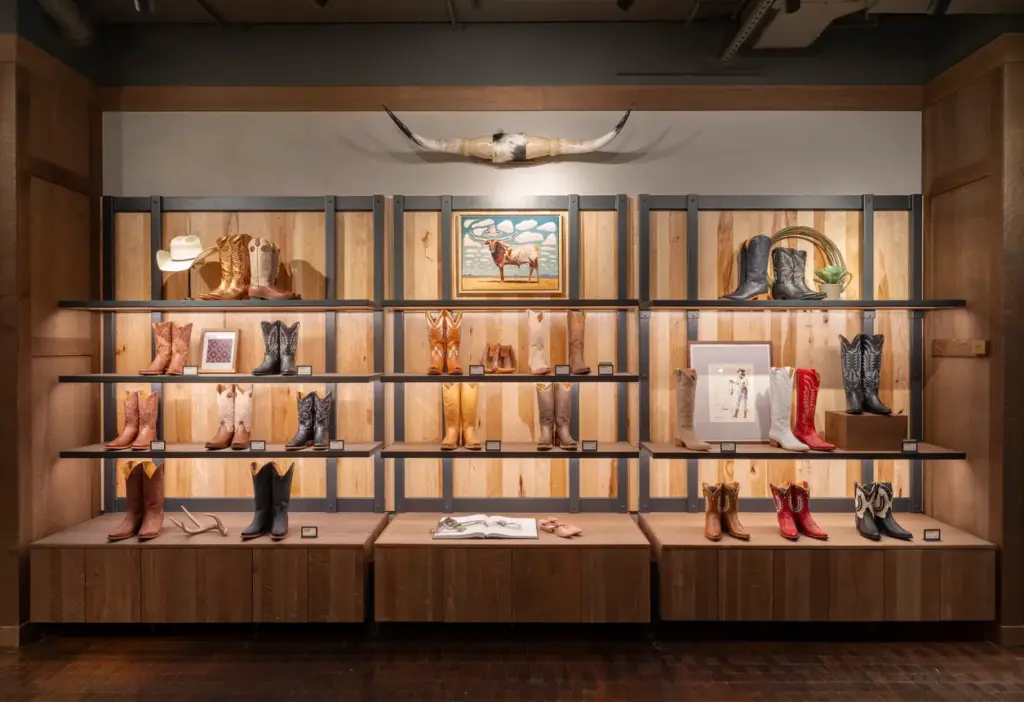 Retail display wall showcasing cowboy boots in a branded store.