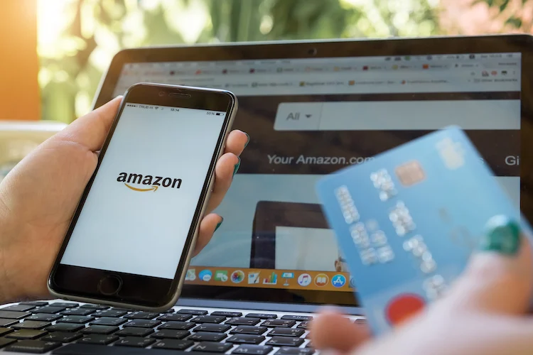 Amazon shopping refund process with phone, laptop, and payment card.