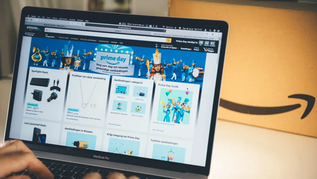Laptop displaying Amazon Prime Day deals beside an Amazon delivery box.