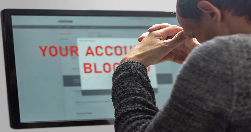 Seller viewing a computer screen showing an account blocked message after an Amazon suspension.